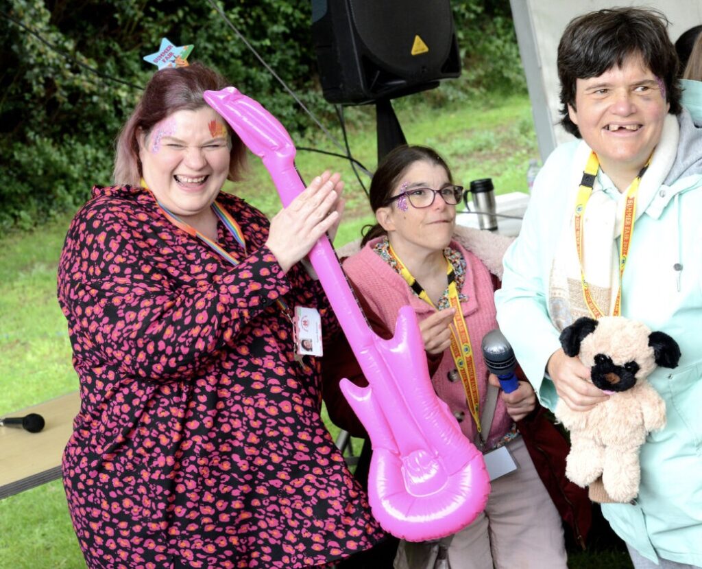 Individuals at party with inflatable guitar