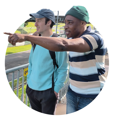 Support worker and individual service user watching go karts